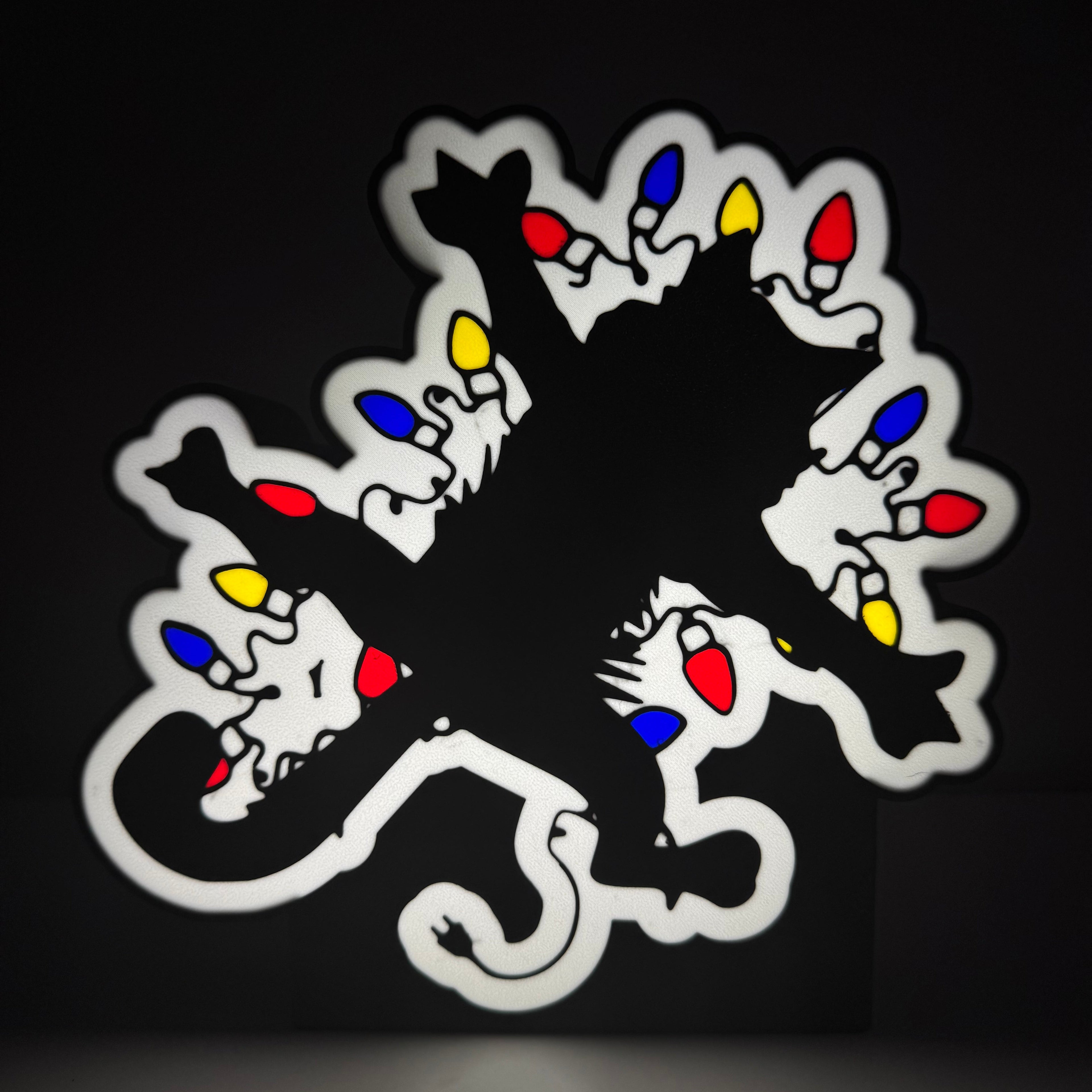 Decorative lightbox with a black central design and colorful lights on a dark background
